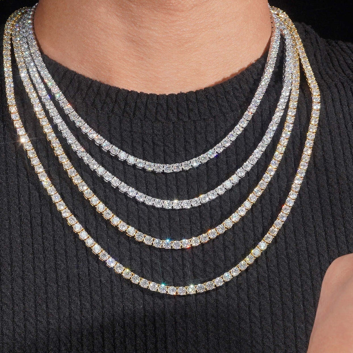Person wearing multiple diamond necklaces.